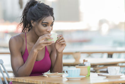 Portrait of young woman drinking coffee