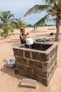 African girl picks up water from a well that is used, among other things, for washing clothes, ghana 