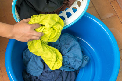 High angle view of baby hand holding water in container