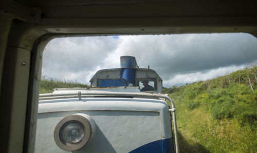 Engineer driving train against cloudy sky