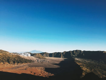 Scenic view of desert against clear blue sky