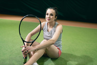 Tennis player sitting on at court