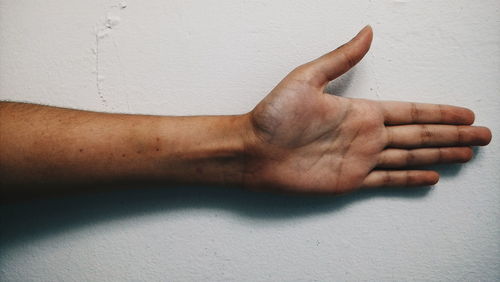 Close-up of human hand over white background