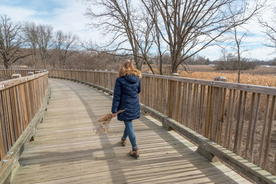 Rear view of girl walking on footbridge