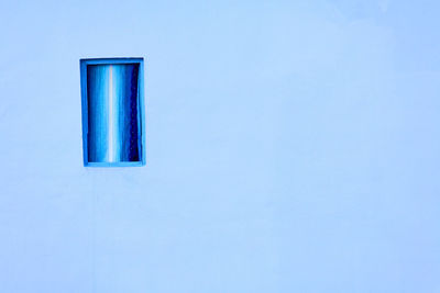 Closed window on blue wall