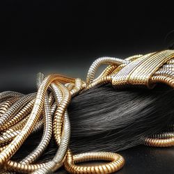 Close-up of pipes and hair against black background