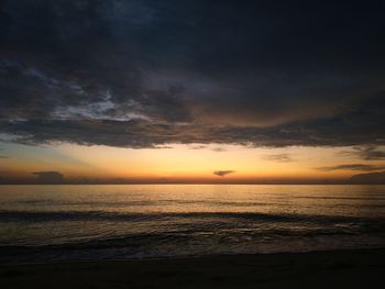 Scenic view of sea against dramatic sky during sunset