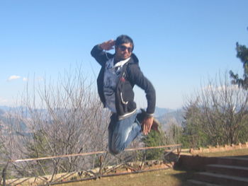 Full length of man standing on field against clear sky