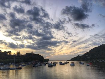 Boats in sea against cloudy sky