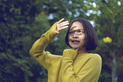 Teenage girl shield eyes against trees