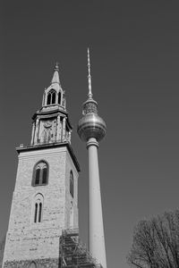 Low angle view of church tower and fernsehturm berlin against sky