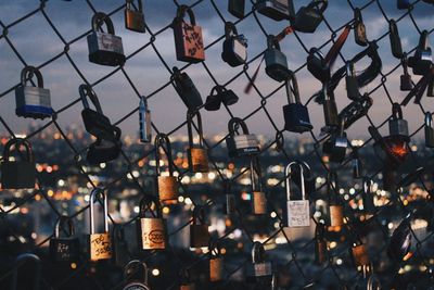 Close-up of padlocks hanging on chainlink fence