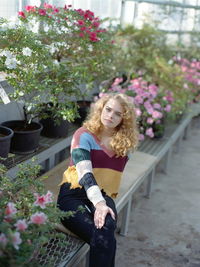 Portrait of woman with pink flower in pot