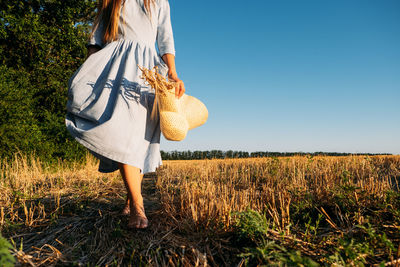 Physical and mental well-being. faceless portrait of woman in linen dress enjoys nature on sunset