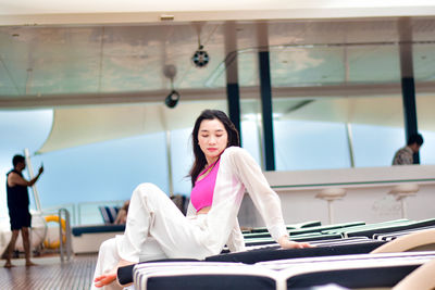 Portrait of smiling young woman sitting in gym