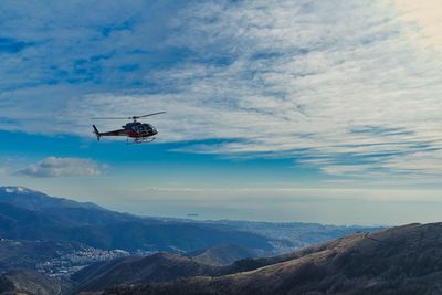 Low angle view of helicopter flying against sky