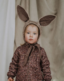 Close up portrait of toddler baby girl in funny hat with ears having fun