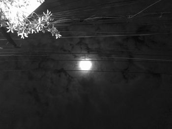 Low angle view of illuminated lights against wall at night