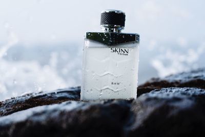 Close-up of glass bottle on snow