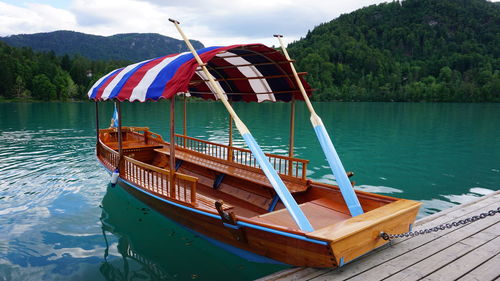 Boat moored on lake against trees