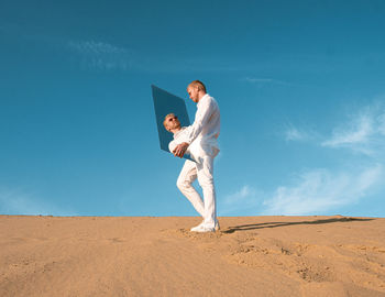 Low angle view of young man jumping against sky