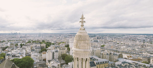 Aerial view of city against cloudy sky