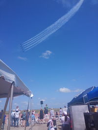 People on beach against blue sky