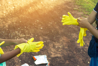 Low section of people holding yellow flower