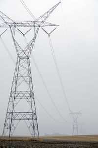 High tension power line towers in fog