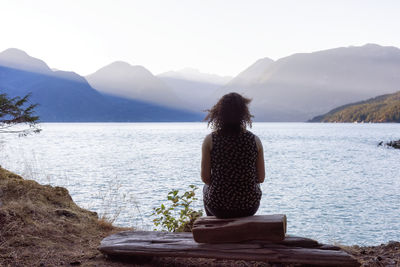 Rear view of woman looking at mountains against sky