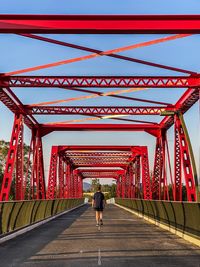 Rear view of woman on bridge against sky