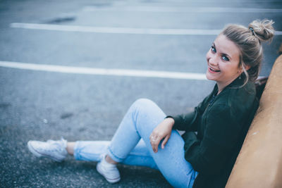 Young woman sitting on road