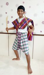 Portrait of boy holding swords at home