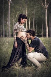 Rear view of couple on field in forest