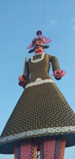 Low angle view of man roof against blue sky