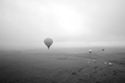 Hot air balloon flying over landscape against sky
