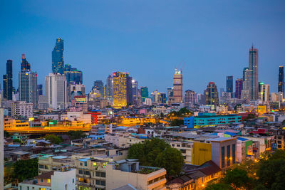 Modern buildings in city against clear blue sky