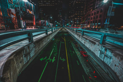 Illuminated railroad tracks in city at night