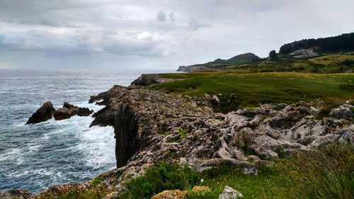 Scenic view of rocks on beach against sky