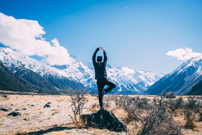 Man standing on snowcapped mountain against sky