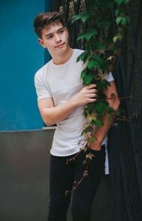 Portrait of smiling young woman standing by plants