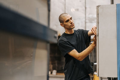 Shaved head male worker working in manufacturing industry