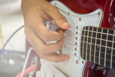 Midsection of man playing guitar