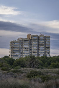 Building emerging from the vegetation at sunset