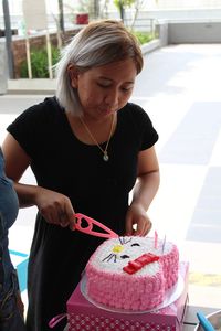 Young woman cutting cake