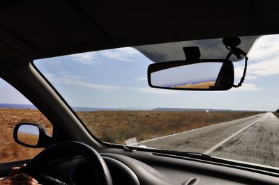 Close-up of side-view mirror seen through car window