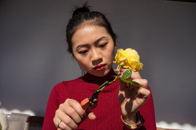 Portrait of woman holding red flower