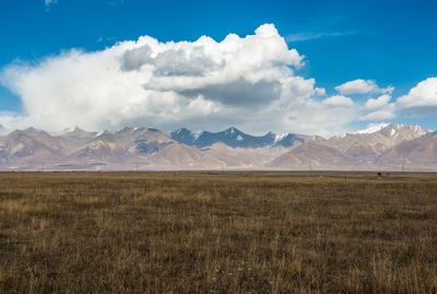 Scenic view of land and mountains against sky