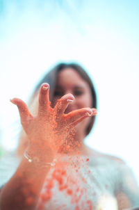 Close-up portrait of young woman playing with colored powder