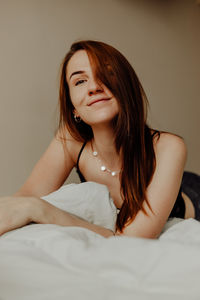 Portrait of beautiful woman lying on bed at home